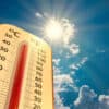 climate change, low angle view Thermometer on blue sky with sun shining in summer show increase temperature, concept global warming